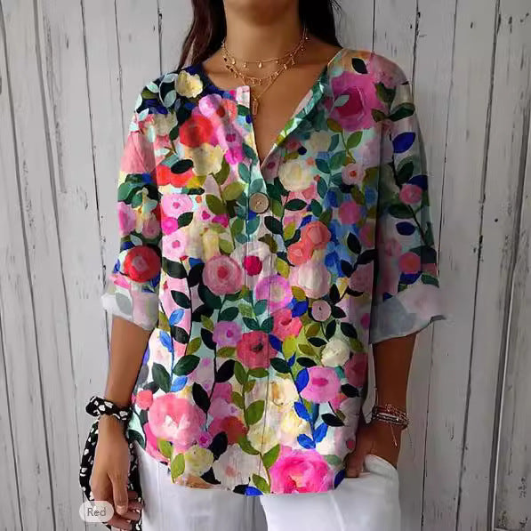 Frau trägt bunte, florale Bluse vor Holzwand. Modetrend, Damenmode, Frühlingsoutfit, Blumenmuster, lässiger Stil, modische Bluse.
