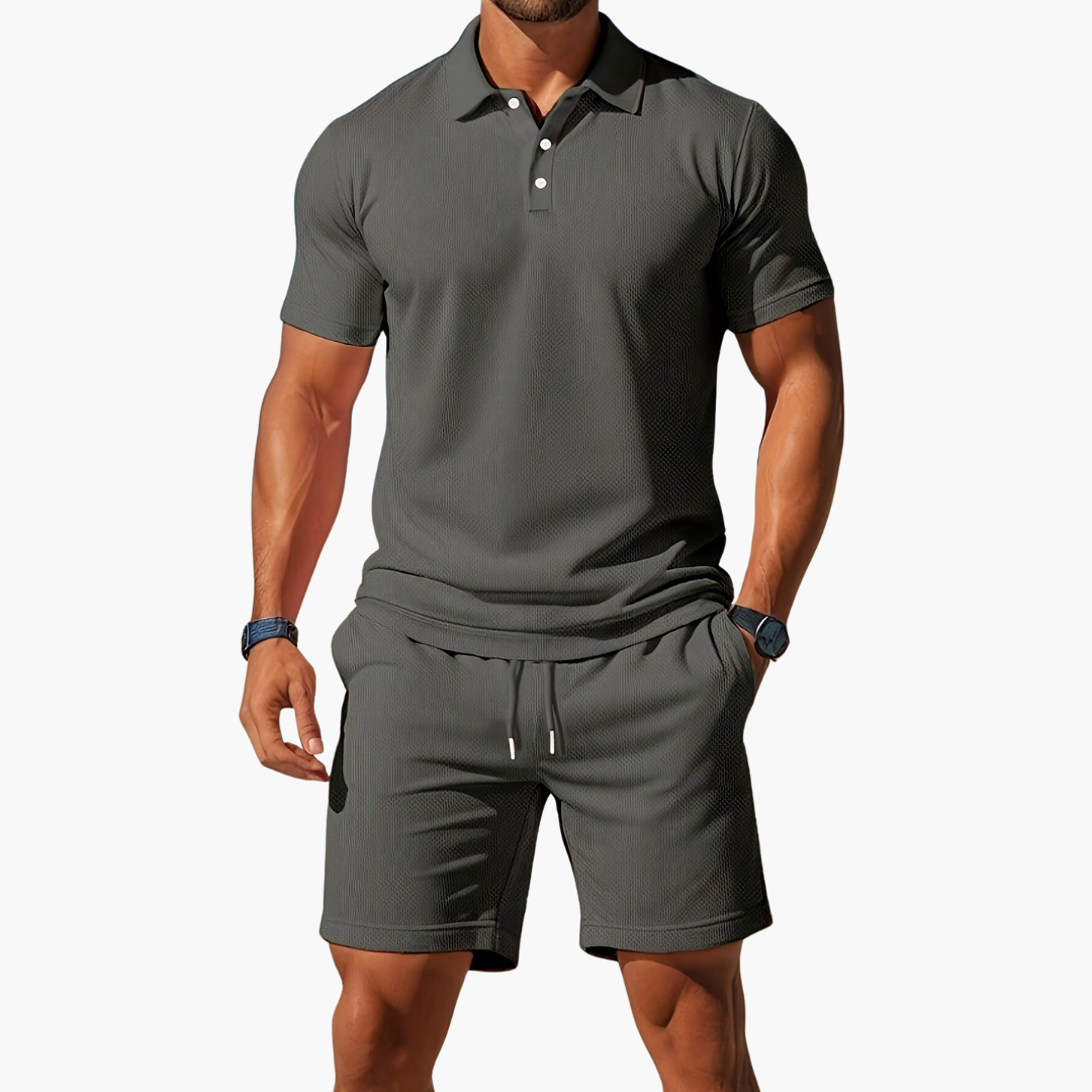 Mann in grauem Poloshirt und Shorts, sportlich-eleganter Look, Sommermode für Herren, Freizeitoutfit, stilvolle Herrenbekleidung.