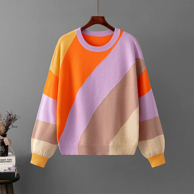 Bunter Damenpullover mit geometrischem Muster in Orange, Lila und Beige, aus weichem Strickmaterial. Modischer Herbst-Winter-Look.
