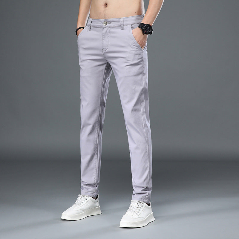 Graue Chinohose für Herren, modern geschnitten, kombiniert mit weißen Sneakers. Ideal für Freizeitmode und stilvolle Alltagsoutfits.