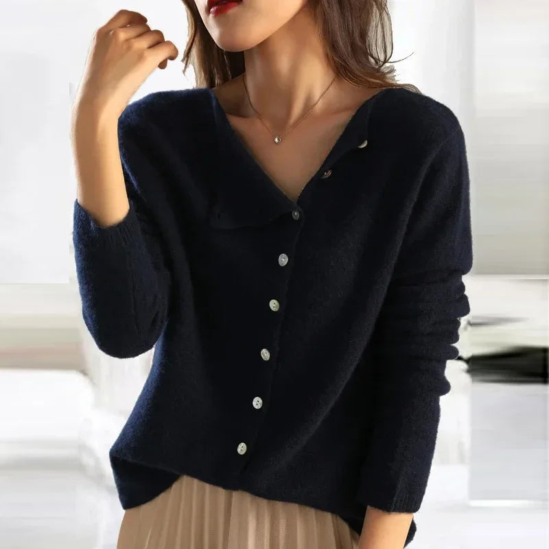 Dunkelblauer Damenpullover mit V-Ausschnitt und Knopfleiste, kombiniert mit beigem Rock. Modischer Herbst-Look, elegant und stilvoll.