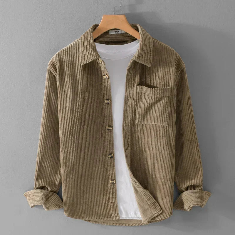Braunes Cordhemd auf Kleiderbügel, über weißem T-Shirt. Modische Herrenbekleidung, lässiger Stil, ideal für Herbstmode und Freizeitoutfits.