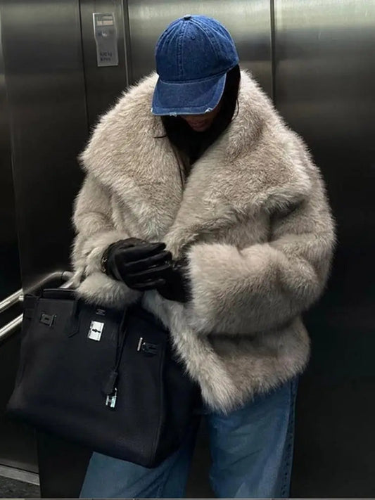 Frau im Aufzug mit Pelzmantel, blauer Baseballkappe, schwarzer Lederhandtasche und Handschuhen. Wintermode, luxuriöser Stil, urbane Eleganz.