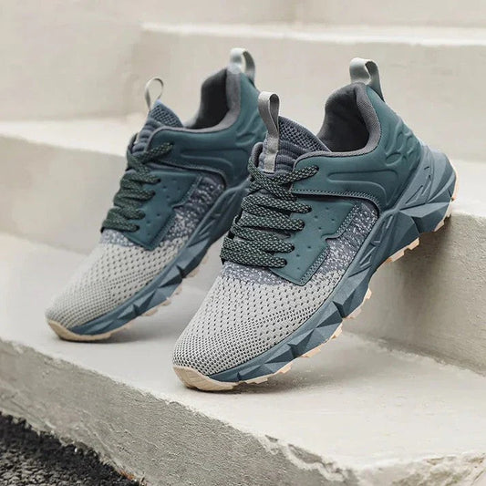 Graue und grüne Sportschuhe auf Treppe, modernes Design, atmungsaktives Mesh, rutschfeste Sohle, ideal für Laufen und Outdoor-Aktivitäten.