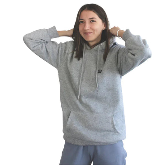 Frau in grauem Hoodie, lächelnd, mit Kapuze und Kordelzug, lässige Mode, bequeme Freizeitkleidung, isoliert auf weißem Hintergrund.